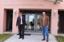 Zwei Männer stehen vorm Dienstgebäude des ALE Niederbayern
