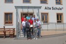 Acht Herren stehen auf der Treppe vorm Eingang zur Alten Schule Obermiethnach