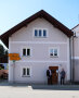 Zwei Männer stehen vor einem Haus mit der Haus-Nr. 17 und halten eine Plakette in der Hand