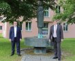 Zwei Männer stehen vorm „Ludwigsbrunnen“ am ALE Niederbayern in Landau a.d.Isar