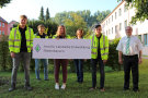 Eine Gruppe Meschen, zum Teil mit Warnwesten stehen im Freien und halten dabei ein Schild mit der Aufschrift Amt für Ländliche Entwicklung Niederbayern
