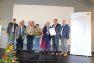 Sieben Herren und drei Damen während eines Gruppenfotos im Rahmen der Preisverleihung auf der Bühne im Bürgerhaus Zeilarn.