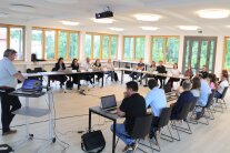 Vertreter des ALE Niederbayern und des Landesamtes für Digitalisierung, Breitband und Vermessung sitzen an einem „Runden Tisch“ in einem großen Saal.