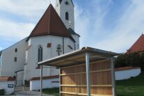 Vor der Pfarrkirche St. Petrus und Paulus in Peterskirchen steht das neue Buswartehäuschen