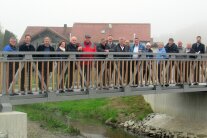 17 Personen stehen nebeneinander auf der neu gebauten Kinsachbrücke in Ascha