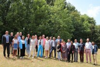 24 Personen posieren nebeneinander für ein Gruppenfoto am Isardamm in Landau a.d.Isar.