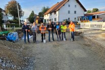 Sieben Herren stehen auf einer, in Bau befindlichen, Straße in Buchhofen und halten symbolisch Spaten in ihren Händen