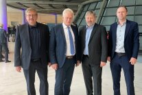 Vier Herren in feinen Zwirn stehen nebeneinander im Foyer des Deutschen Bundestages