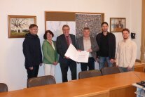 Fünf Herren und eine Frau vollziehen im Rathaus der VG Oberpöring die offizielle Einleitung der Flurneuordnung Wallerfing Süd.