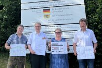 Drei Herren und eine Dame halten die Baupläne für das neue Bürgerhaus in Loitzendorf in ihren Händen