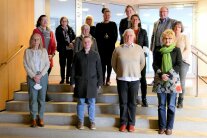 Dreizehn Personen, davon zwölf Damen und ein Herr stehen auf einer Treppe im Landratsamt Deggendorf.