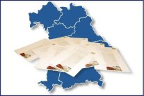 Blaue Karte mit den sieben Regierungsbezirken von Bayern und Broschüren im Vordergrund