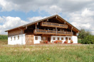Saniertes 3-geschossiges Bauerhaus; OG und DG sind in Holzblockbauweise; das EG ist massiv und weiß 